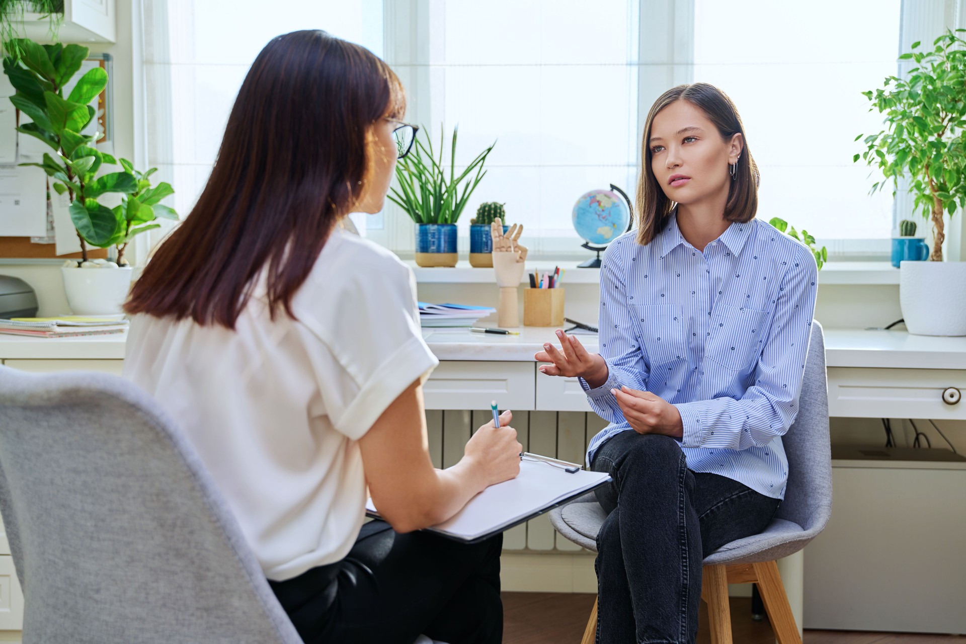 Young woman at mental therapy, talking to female psychologist